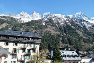 a building in front of a mountain with snow at Hôtel Richemond in Chamonix