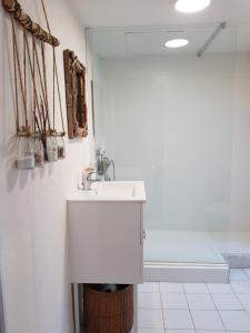 La salle de bains blanche est pourvue d'un lavabo et d'un miroir. dans l'établissement Studio Chantilly, à Coye-la-Forêt