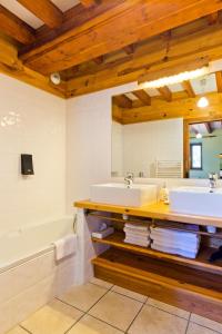 a bathroom with two sinks and a tub and a bath tub at Auberge de la Hulotte in Saint-Jacques-dʼAmbur