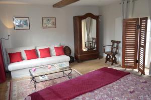 sala de estar con sofá blanco y almohadas rojas en Domaine de la Castagnère, en Castetnau-Camblong
