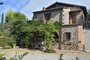una vieja casa de piedra con una mesa delante en Il Fornacino, en Rapolano Terme