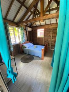 a bedroom with a bed in a wooden house at An Ti Kaz La in Sainte-Anne