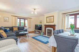 a living room with a couch and a fireplace at Simdde Wen in Beaumaris