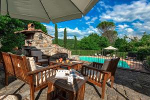 a patio with chairs and a fireplace and a pool at Casale del Lago in San Casciano in Val di Pesa