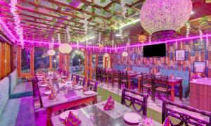 a dining room with pink lighting and tables and chairs at The Alpine Villa Mcleodganj in McLeod Ganj +57 photos