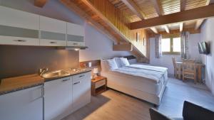 Habitación pequeña con cama y cocina en Le Chamois, en Les Diablerets