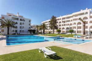 ポルシェスにあるAndorinha 2 bedroom apart-close to the sea-Algarveの大きな建物の前のスイミングプール