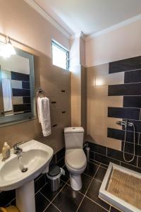 a bathroom with a white toilet and a sink at Katerina Rooms & Apartments in Skala Potamias