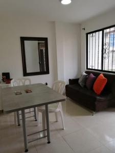 a living room with a black couch and a table at Apartamento completo medellin in Medellín