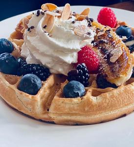 a waffle with fruit and whipped cream on a plate at The Rockaway Hotel in Queens