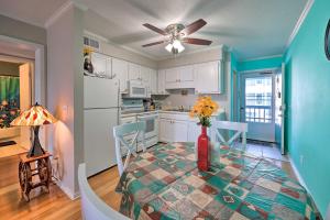 a kitchen with a table with a vase of flowers on it at Condo with Balcony and Pool Walk to 2 Beach Accesses! in Carolina Beach