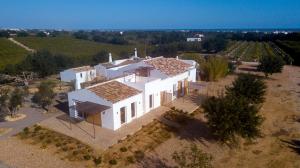 uma vista superior de uma grande casa branca com árvores em Quinta da Pintassilga em Tavira