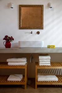 a bathroom with a sink and a mirror and towels at Quinta da Pintassilga in Tavira