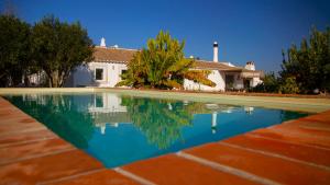 a pool of water in front of a house at Quinta da Pintassilga in Tavira