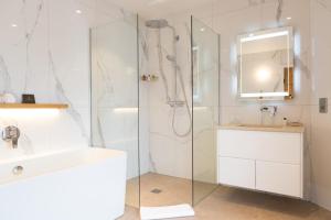 a white bathroom with a shower and a sink at Pentonbridge Inn - Restaurant with Rooms in Carlisle