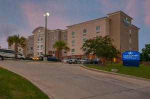 un hotel con un cartello di fronte a un parcheggio di Candlewood Suites - Baton Rouge - College Drive, an IHG Hotel a Baton Rouge