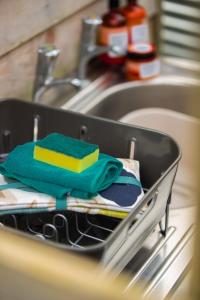 a dish drying rack in a sink with towels at Snowdonia Hideaway in Tywyn