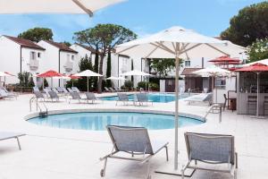 a swimming pool with chairs and umbrellas at Art&Park Hotel Union Lido in Cavallino-Treporti