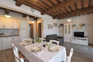 a dining room with a table and a kitchen at Casa di Campagna Pianelli in Pergine Valdarno