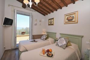 two beds in a room with a view of a balcony at Casa di Campagna Pianelli in Pergine Valdarno +30 photos