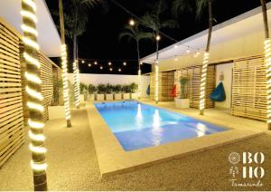 uma piscina numa casa à noite com luzes em BOHO Tamarindo em Tamarindo