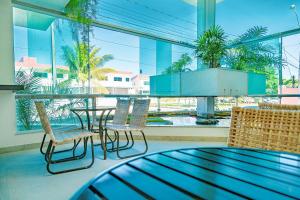 ポルト・セグロにあるVitoria Regia Praia Hotelのテーブルと椅子、大きな窓が備わる客室です。