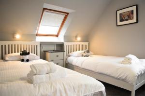 a attic bedroom with two beds with towels on them at 5 Glenconon Bed and Breakfast in Uig