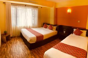 a hotel room with two beds and a window at Yeti Inn Pvt. Ltd. in Kathmandu