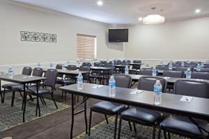 una habitación con mesas y sillas y botellas de agua. en Candlewood Suites Houston Westchase - Westheimer, an IHG Hotel en Houston