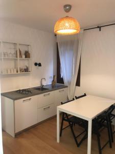 a kitchen with a table and a sink and a table at Casa Vacanze Giorgetta Palazzina privata di due piani in Chioggia