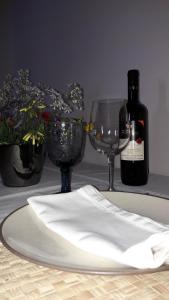 基帕里夏Tzanetos Seaside的一张桌子,上面放着两杯酒和一瓶葡萄酒