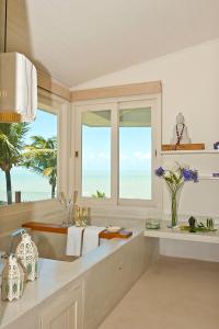 a bathroom with a sink and a large window at Pipa Privilege Suítes in Pipa