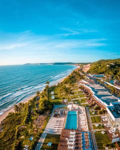 an aerial view of a beach with umbrellas and the ocean at Pipa Privilege Suítes in Pipa