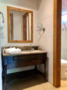 uma casa de banho com um lavatório e um espelho em Pousada Pataca de prata - Pousada de Época em Petrópolis