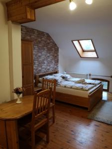 1 dormitorio con cama, mesa y ventana en Őrségi Malom Panzió, en Bajánsenye