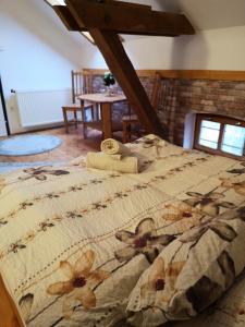 a bedroom with a bed with a floral bedspread at Őrségi Malom Panzió in Bajánsenye