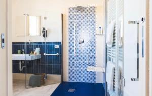 La salle de bains bleue est pourvue d'une douche et d'un lavabo. dans l'établissement Mare e marmellata, à Ravenne