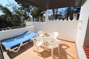 a patio with a table and chairs on a balcony at Apartaments Talayot in Cala en Blanes