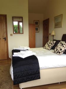 a bedroom with a large bed with black and white pillows at 2 Bed Barn near Newport Shropshire in Newport