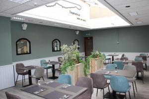 a restaurant with tables and chairs in a room at Hotel "De Klok" in Buren