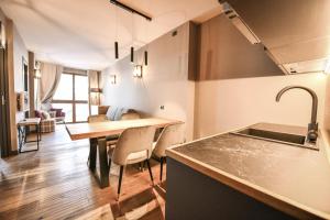 kuchnia i jadalnia ze stołem i krzesłami w obiekcie Chalet Everest - Luxury Apartments w mieście Prato Nevoso +37 zdjęć