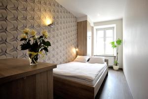 a bedroom with a bed and a vase of flowers at Hostel Promenada in Rzeszów