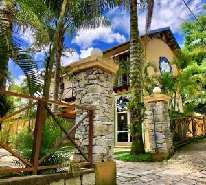 a house with palm trees in front of it at Pousada Pataca de prata - Pousada de Época in Petrópolis