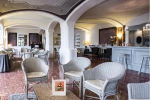 バヴェーノにあるHotel Beau Rivageの白い椅子とバーのあるレストラン