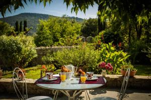 einen Tisch mit Gläsern Orangensaft darauf in einem Garten in der Unterkunft Logis des Magnans - le Murier - in Sauve