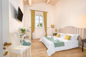 um quarto branco com uma cama e uma cadeira em B&B Borgo di Pratavecchie em Migliarino