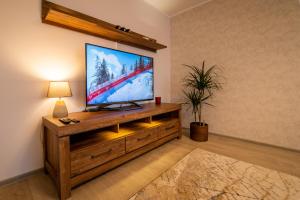 a living room with a flat screen tv on a wooden entertainment center at Otepää Holiday Apartment in Otepää