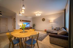 a living room with a table and a couch at Otepää Holiday Apartment in Otepää +26 photos