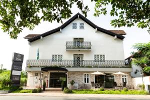 ein großes weißes Gebäude mit Balkon in der Unterkunft Bristol Sabrina Hotel de Charme Joinville in Joinville