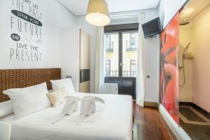 a bedroom with a white bed and a tv at Madrid House Rooms in Madrid